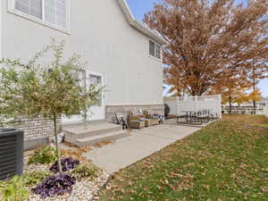 View of side of property featuring outdoor lounge area, a patio area, stucco siding, and brick siding