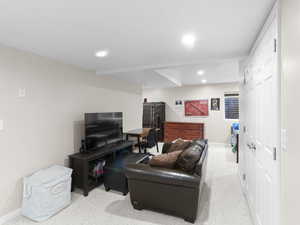 Carpeted living area featuring recessed lighting and baseboards
