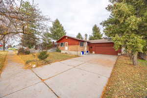 View of front of home featuring concrete driveway, a garage, and brick siding