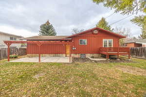 Rear view of house with a pergola, a patio area, board and batten siding, and a wooden deck