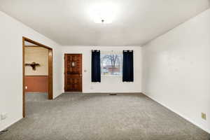 Carpeted spare room with baseboards and a textured ceiling