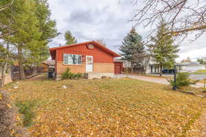 View of side of property with brick siding, board and batten siding, and concrete driveway