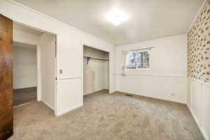 Unfurnished bedroom featuring light carpet, a closet, and a textured ceiling