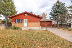View of side of home featuring brick siding, driveway, an attached garage, and board and batten siding