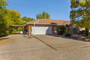 Single story home with stone siding, driveway, a tiled roof, and a garage