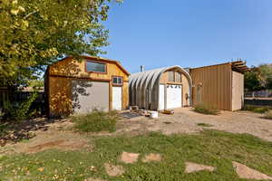 View of front facade featuring an outbuilding and a garage