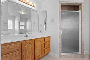Full bathroom with a stall shower, vanity, and light tile patterned flooring