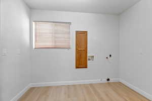 Laundry room with wood finished floors, hookup for a washing machine, hookup for a gas dryer, and electric dryer hookup