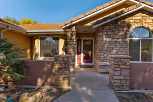 Doorway to property with stone siding and stucco siding