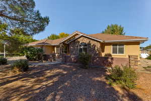Ranch-style house with stone siding, stucco siding, and a tiled roof
