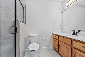 Bathroom with light tile patterned floors, vanity, and a stall shower