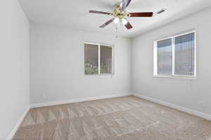 Spare room with carpet floors, ceiling fan, and a textured ceiling