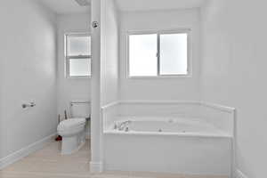 Full bathroom with a tub with jets and light tile patterned floors