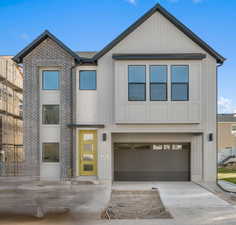 View of front of home featuring a garage, concrete driveway, and brick siding