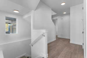 Hallway featuring an upstairs landing and light wood-type flooring