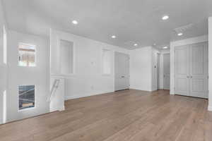 Unfurnished room with light wood finished floors and recessed lighting