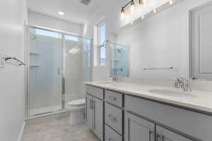 Bathroom featuring double vanity and a shower stall