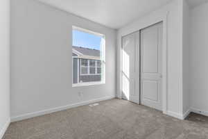 Unfurnished bedroom featuring a closet and carpet floors