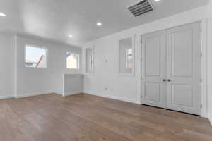 Unfurnished living room featuring light wood-type flooring, recessed lighting, and a textured ceiling