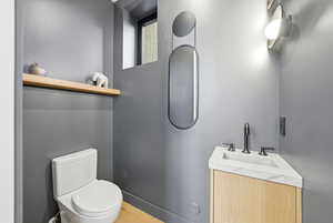 Half bathroom with vanity and toilet