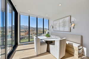 Dining room featuring floor to ceiling windows, a mountain view, recessed lighting, and light wood-type flooring