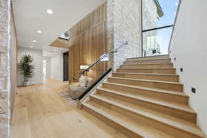 Stairs with recessed lighting, hardwood / wood-style flooring, and an accent wall