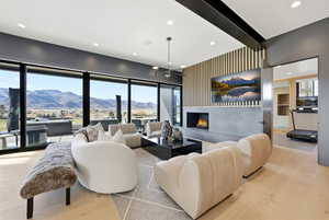 Living room featuring light wood-type flooring, healthy amount of natural light, a lit fireplace, and recessed lighting
