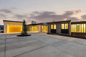 View of front of house with driveway, a chimney, and a garage