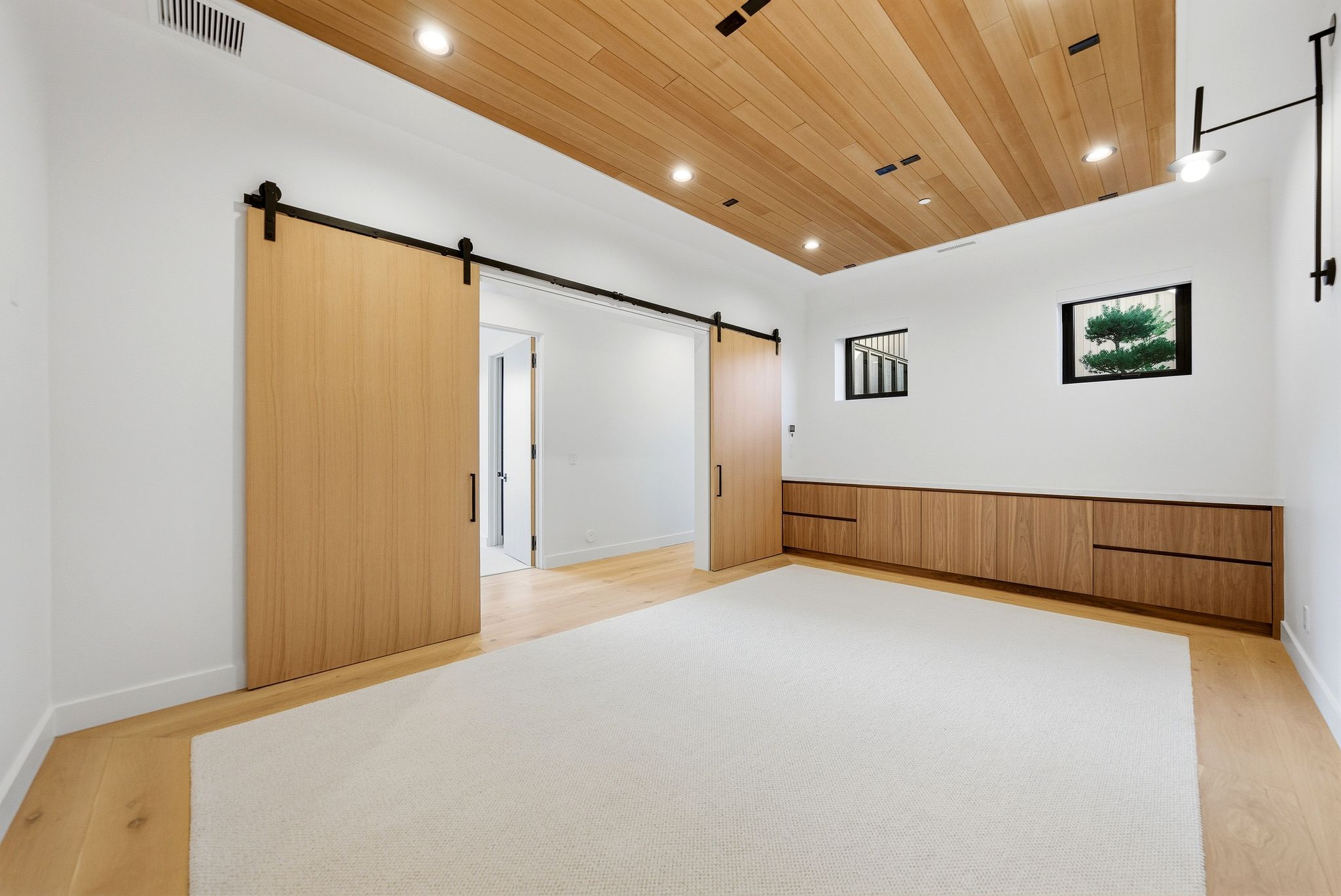 Unfurnished room with a barn door, wooden ceiling, light wood-style flooring, and recessed lighting