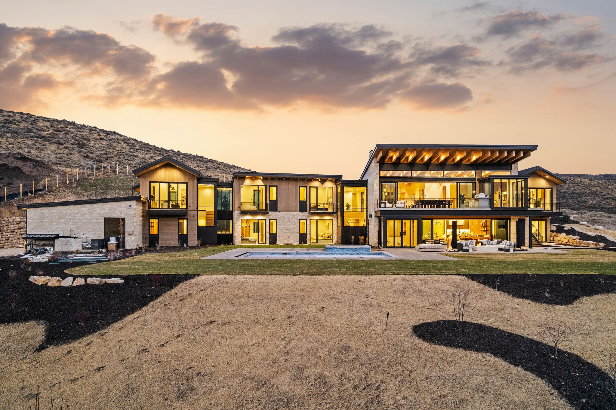 Back of house featuring a balcony, a patio, a hot tub, and a mountain view
