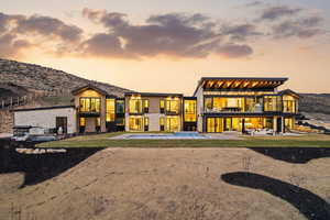 Back of house featuring a balcony, a patio, a hot tub, and a mountain view