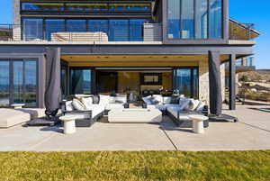 Rear view of house with a patio, outdoor lounge area, and a balcony