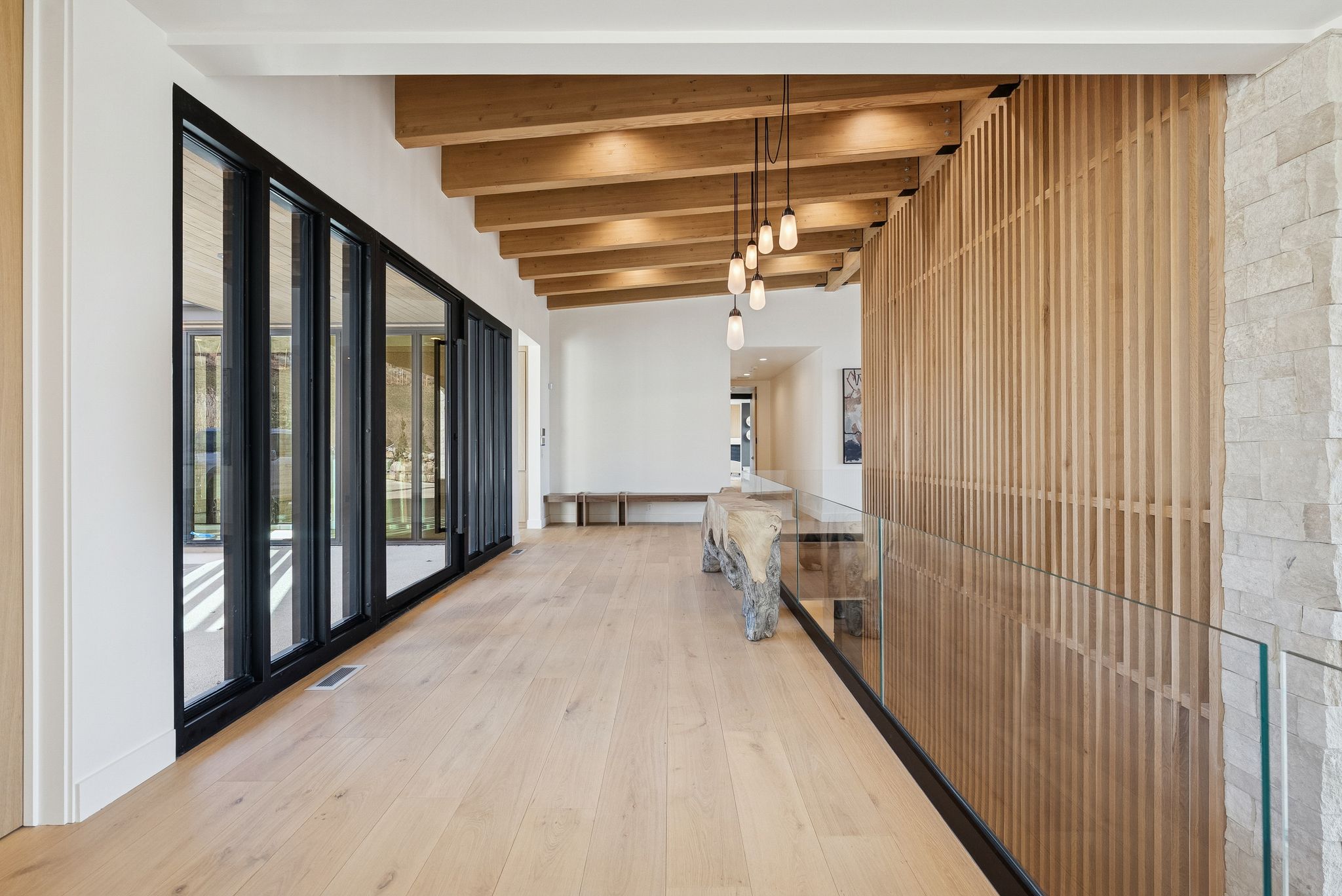 Hallway with light wood-style flooring and beam ceiling