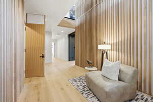 Sitting room featuring recessed lighting, light wood-type flooring, and wood walls