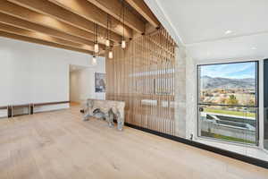 Empty room featuring beam ceiling, wood finished floors, a mountain view, and recessed lighting