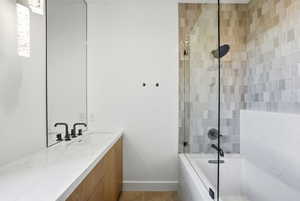 Full bath featuring tiled shower / bath combo and vanity
