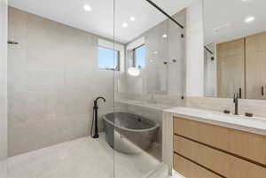Full bath with vanity, a freestanding bath, tile walls, recessed lighting, and tiled shower