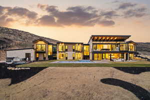 Back of property with a balcony, a patio, a hot tub, and a mountain view