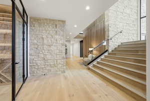 Hallway featuring stairs, light wood-style floors, and recessed lighting