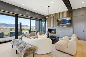 Living area featuring a lit fireplace, light wood finished floors, and recessed lighting