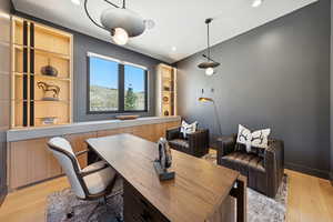 Office area featuring light wood-style floors and recessed lighting