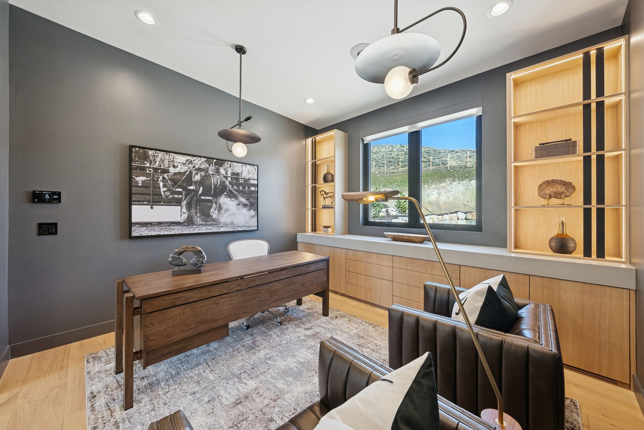 Home office with light wood finished floors and built in features