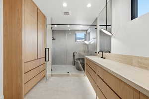 Bathroom featuring vanity, a stall shower, and recessed lighting