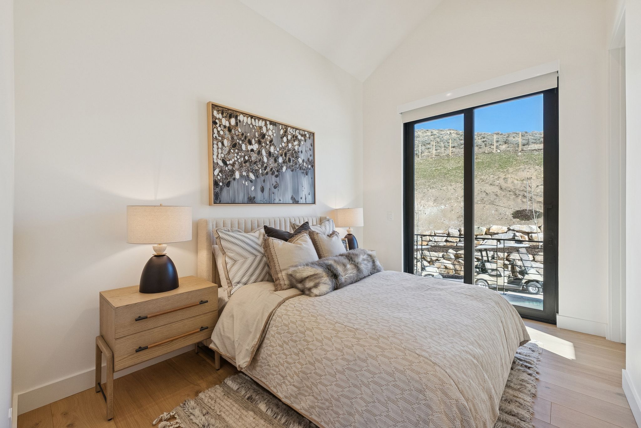Bedroom with lofted ceiling, access to exterior, and wood finished floors