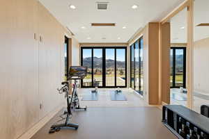 Workout room featuring a mountain view, plenty of natural light, recessed lighting, and expansive windows