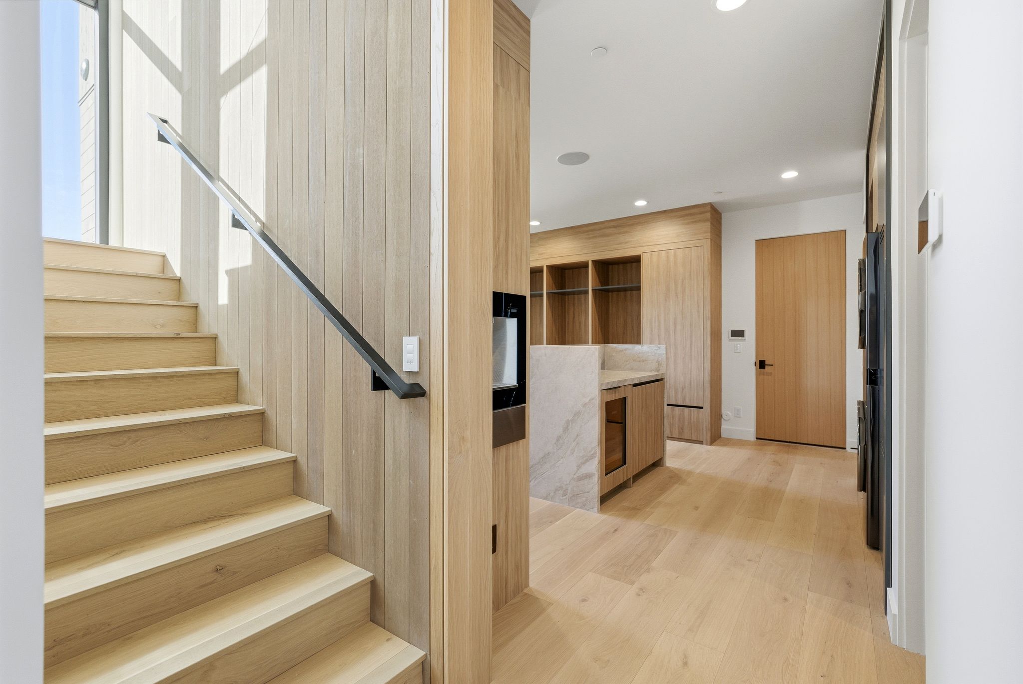Stairs with wood finished floors, recessed lighting, and beverage cooler