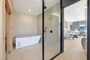 Full bathroom featuring a soaking tub, a stall shower, and recessed lighting