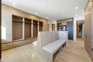 Mudroom featuring built in features, light wood-style floors, and recessed lighting