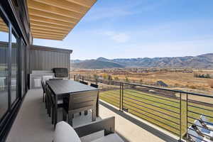Balcony featuring grilling area, a mountain view, and outdoor dining space