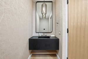 Half bathroom with tile walls and vanity